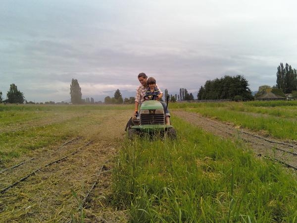 Erin and Jasper Benzakein mowing the lawn