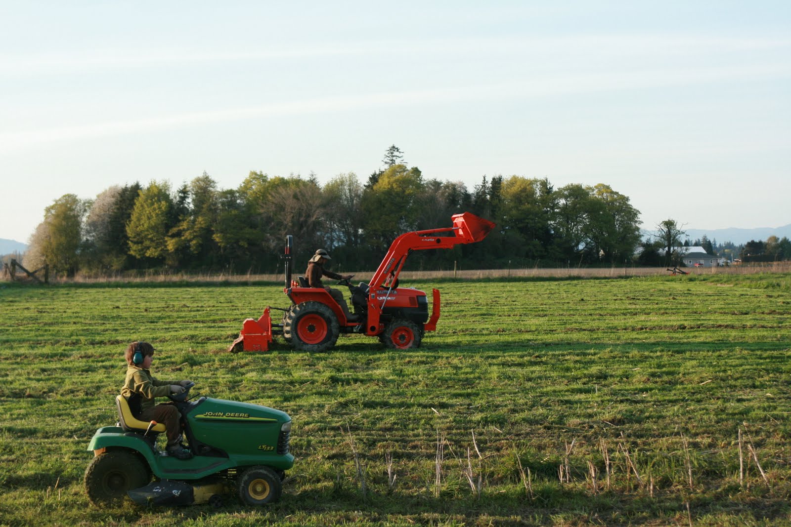 Chris and Jasper Benzakein driving farm equipment