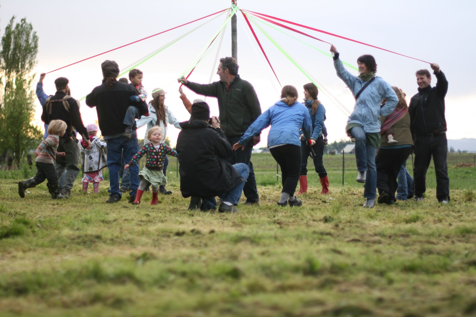 Parents and children dancing around a maypole
