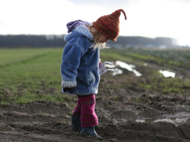 A child in a muddy field