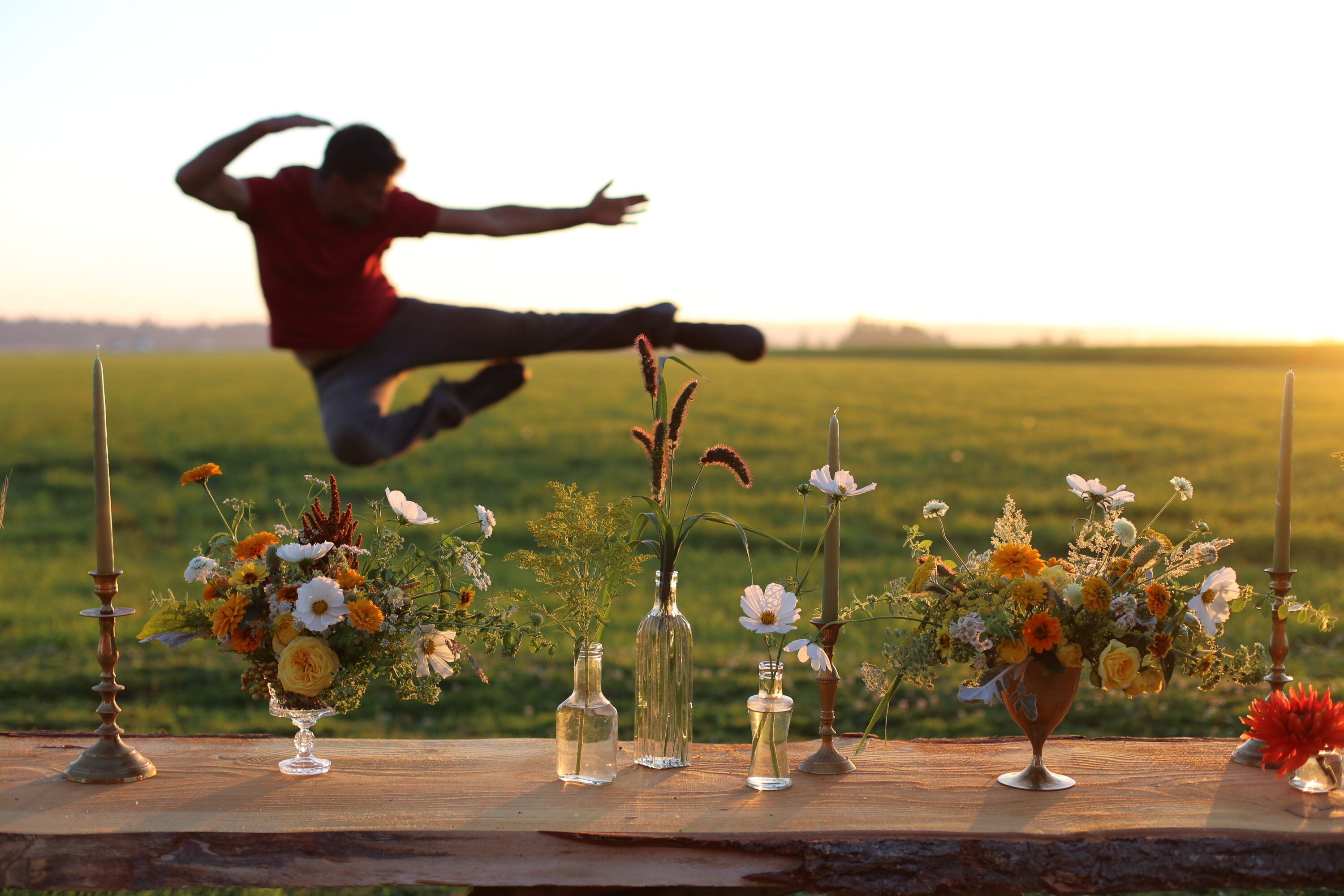 Chris Benzakein jumping midair behind flower arrangements