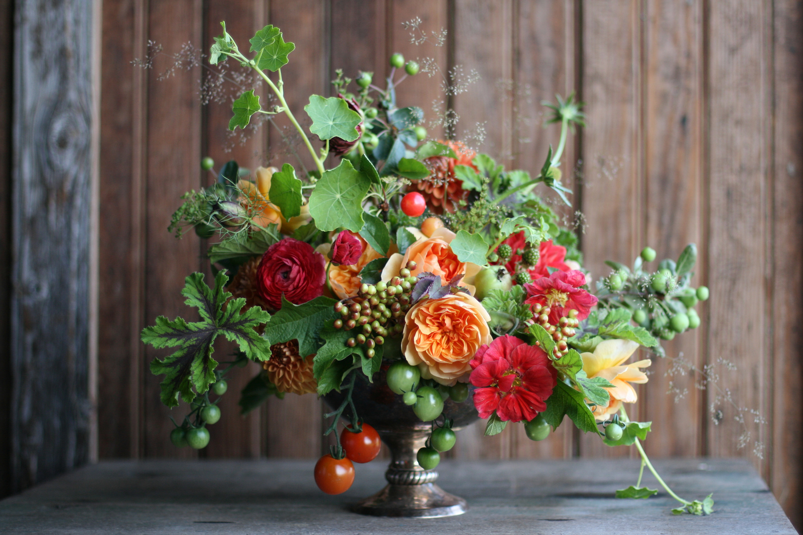 A flower arrangement with tomatoes