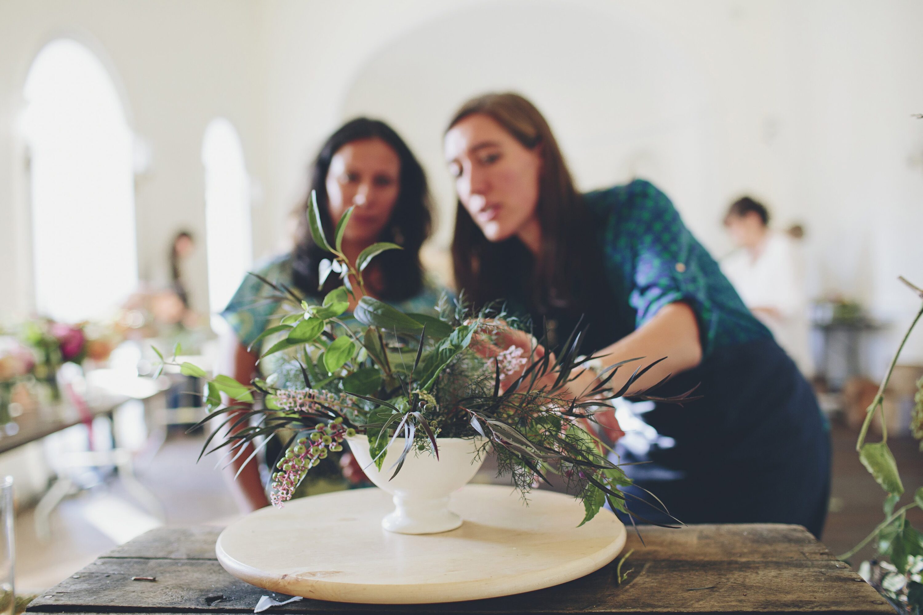 Erin Benzakein teaching a woman how to arrange flowers