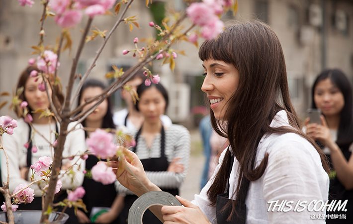 A group of women watching someone arrange flowers