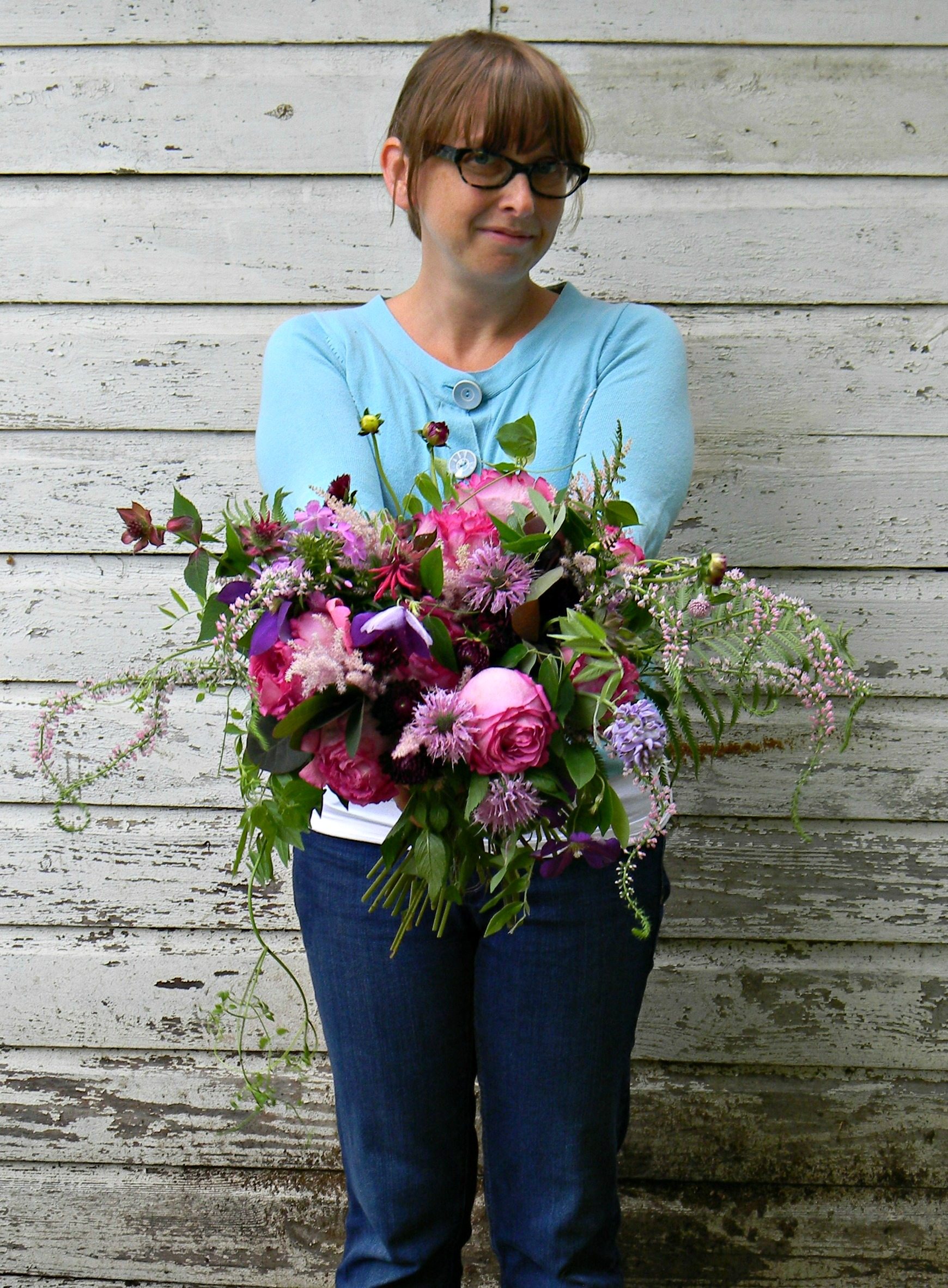 A woman holding a flower arrangement