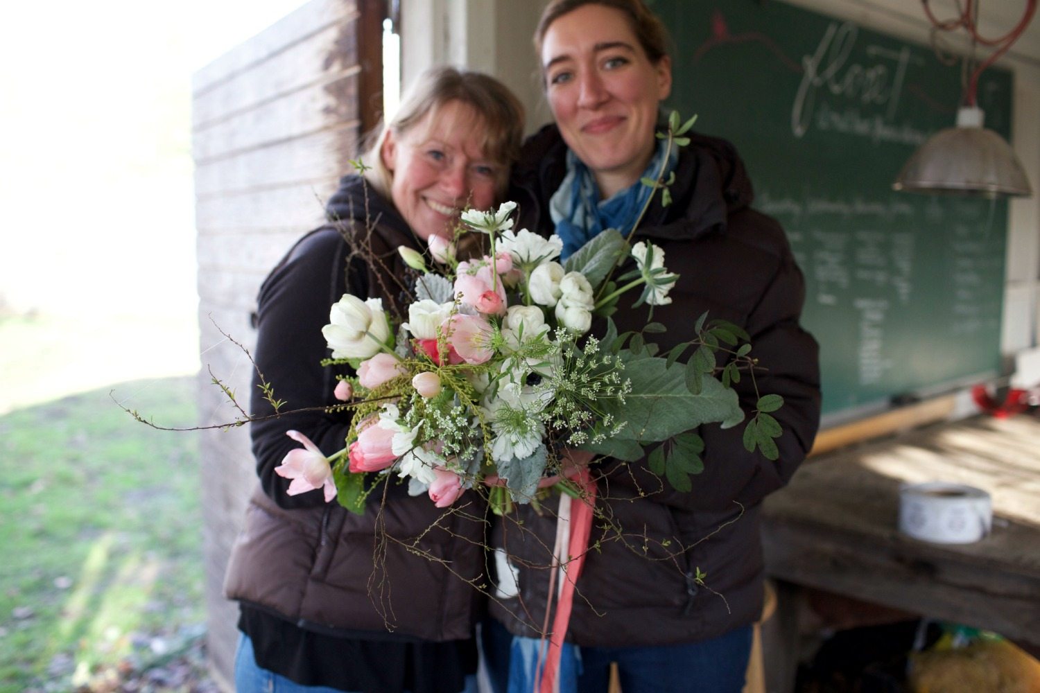 Two women holding a bouquet
