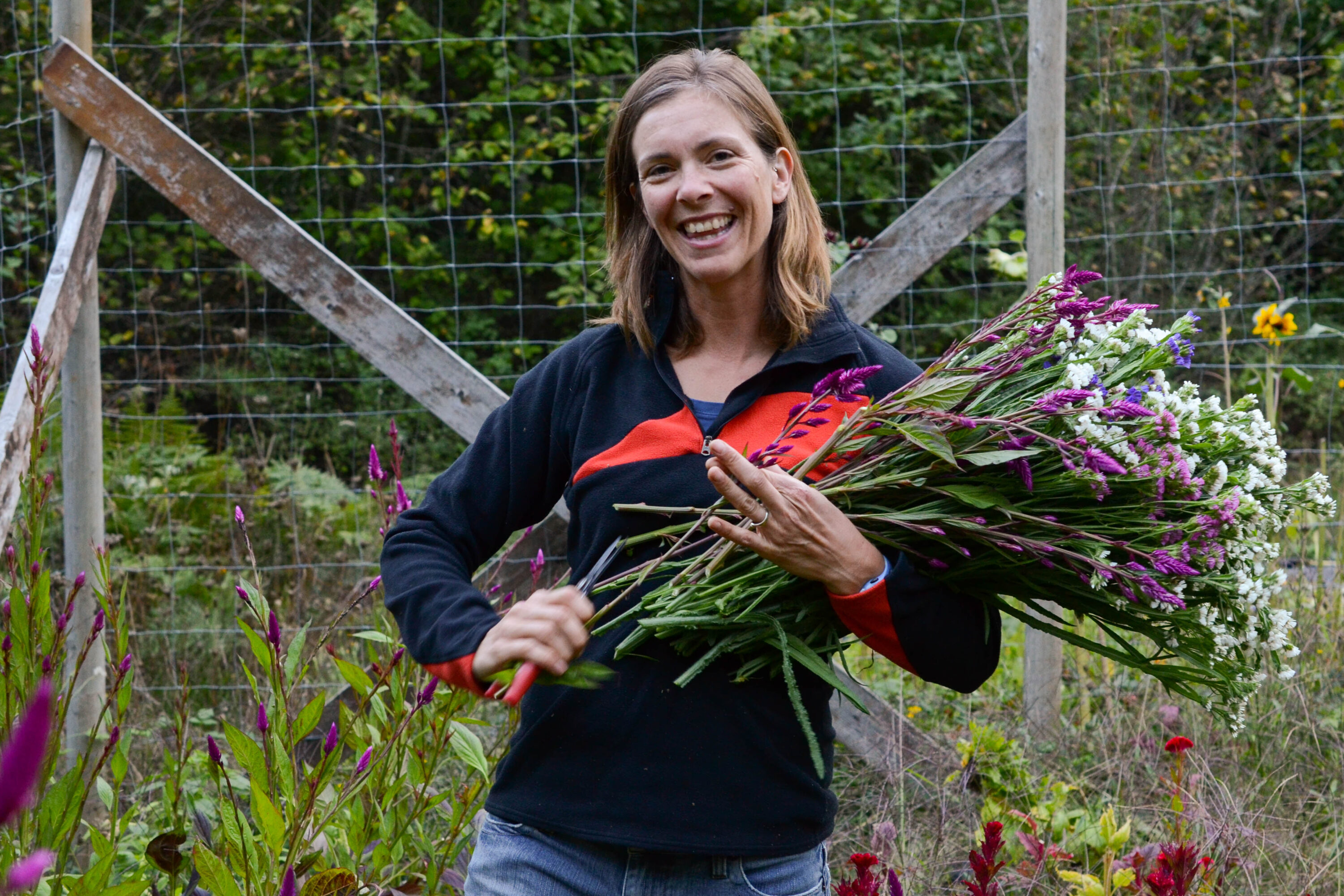 A woman holding an armload of flowers