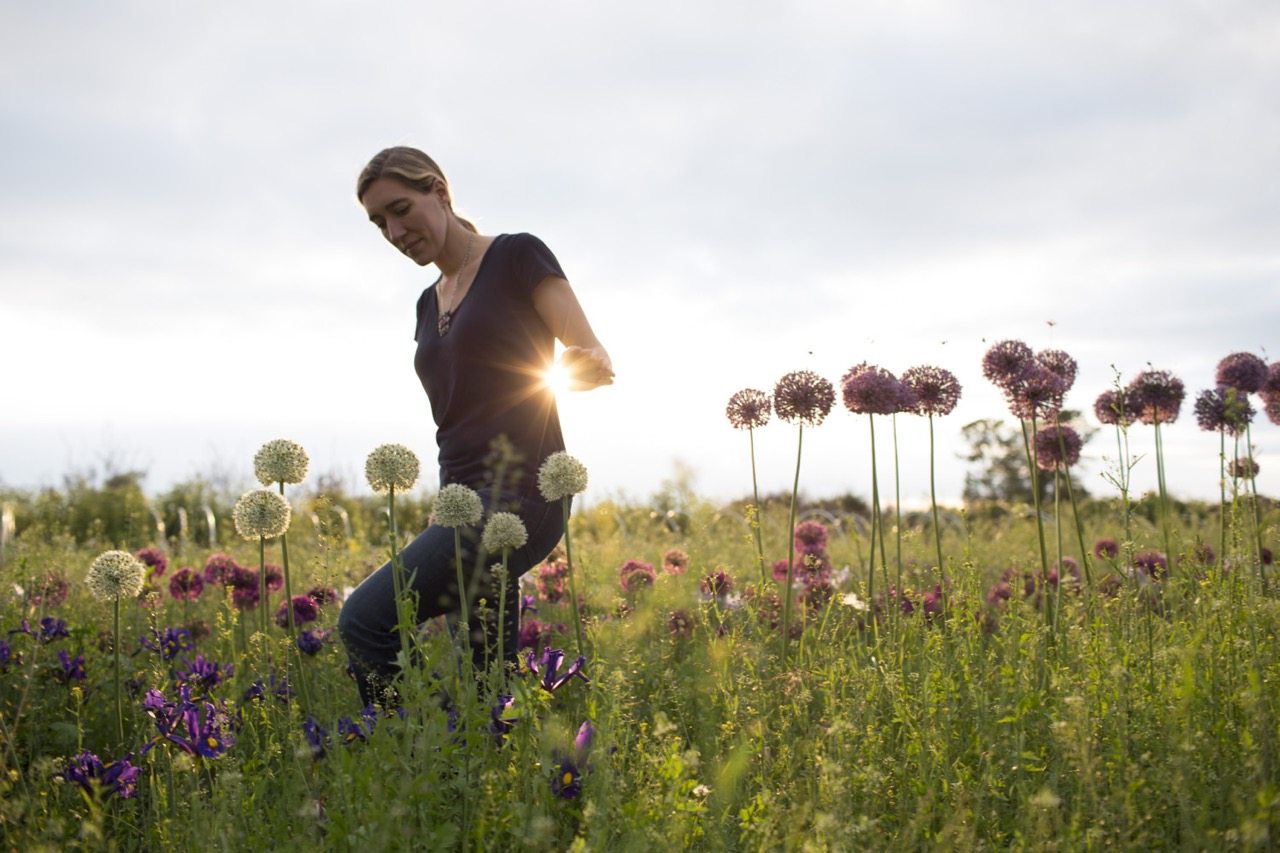 Erin Benzakein walking through a field of flowers