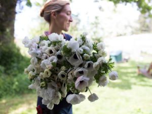 Erin Benzakein holding a large bouquet of black and white anemones