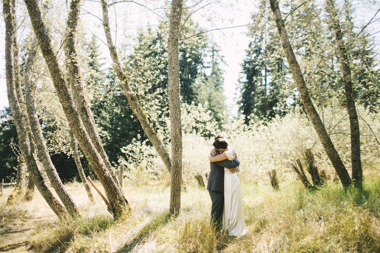 A bride and groom embracing in a forest