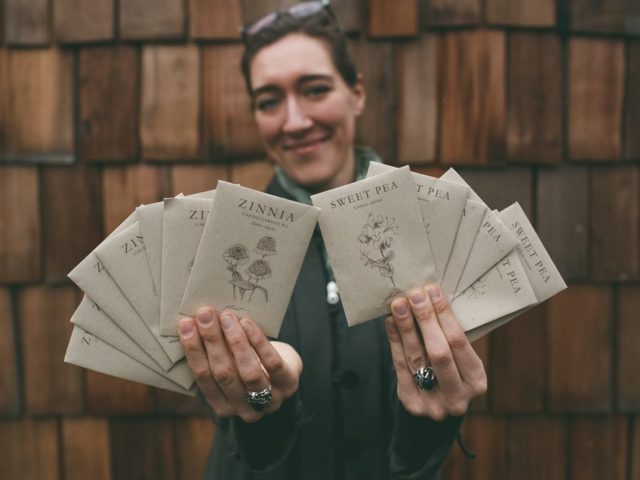 Erin Benzakein holding packets of Floret seeds