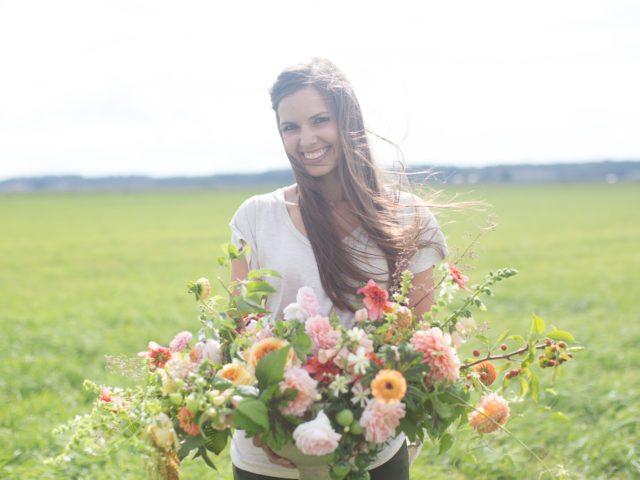 A woman holding a flower arrangement