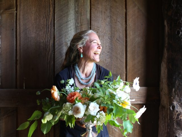 A laughing woman holding a bouquet