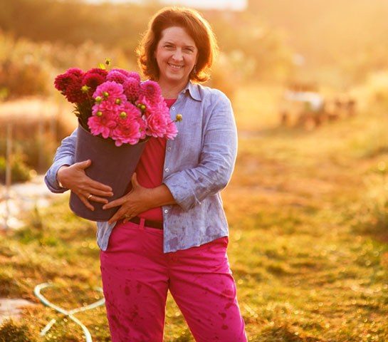 A woman holding a bucket of flowers