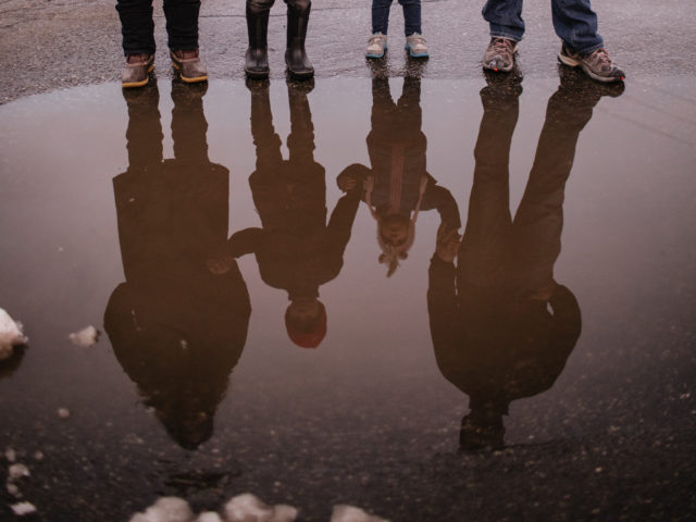 A family reflected in a puddle