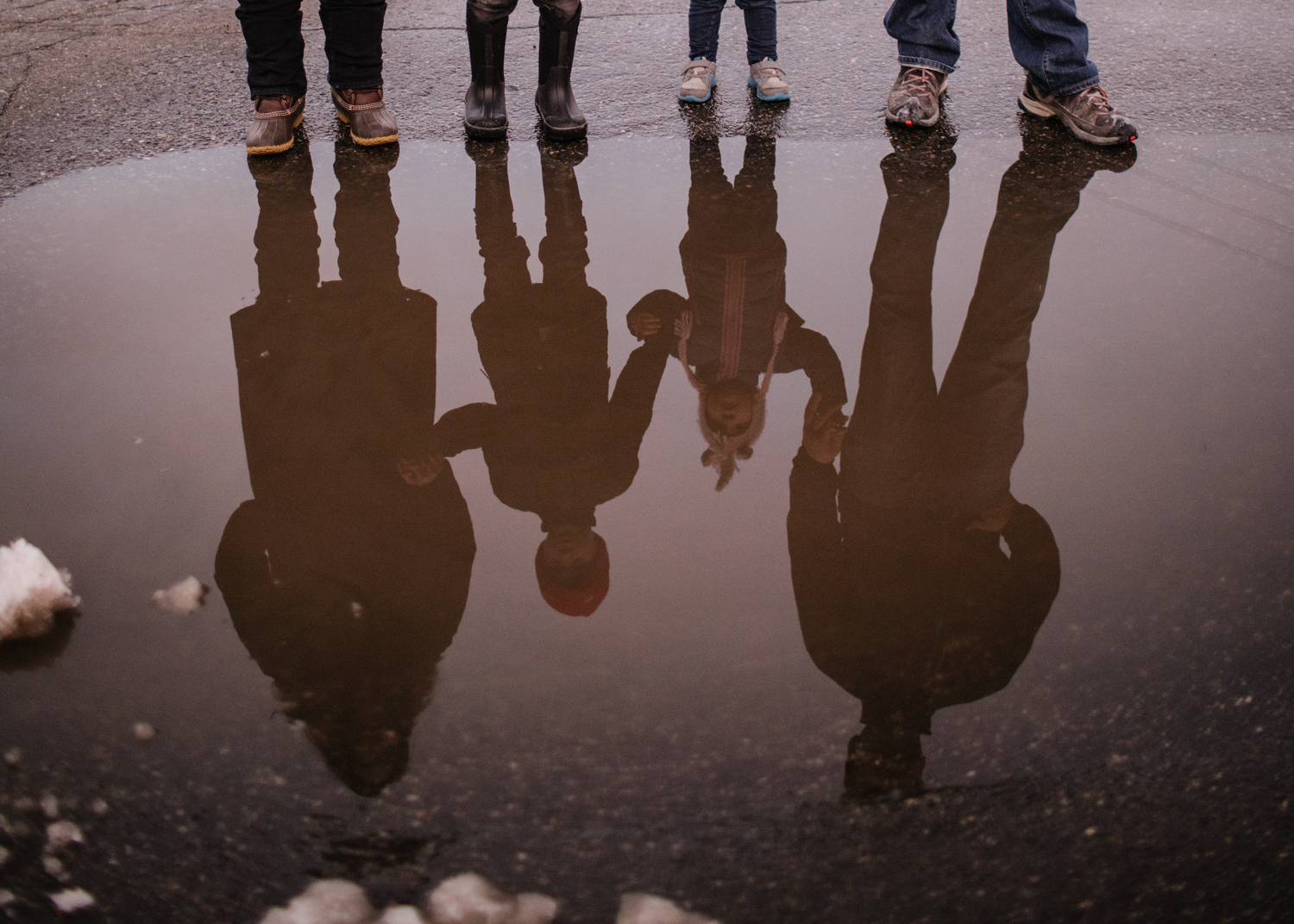 A family reflected in a puddle