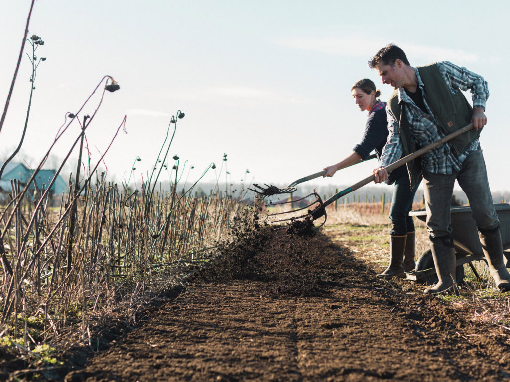 Erin and Chris Benzakein spreading compost onto a field