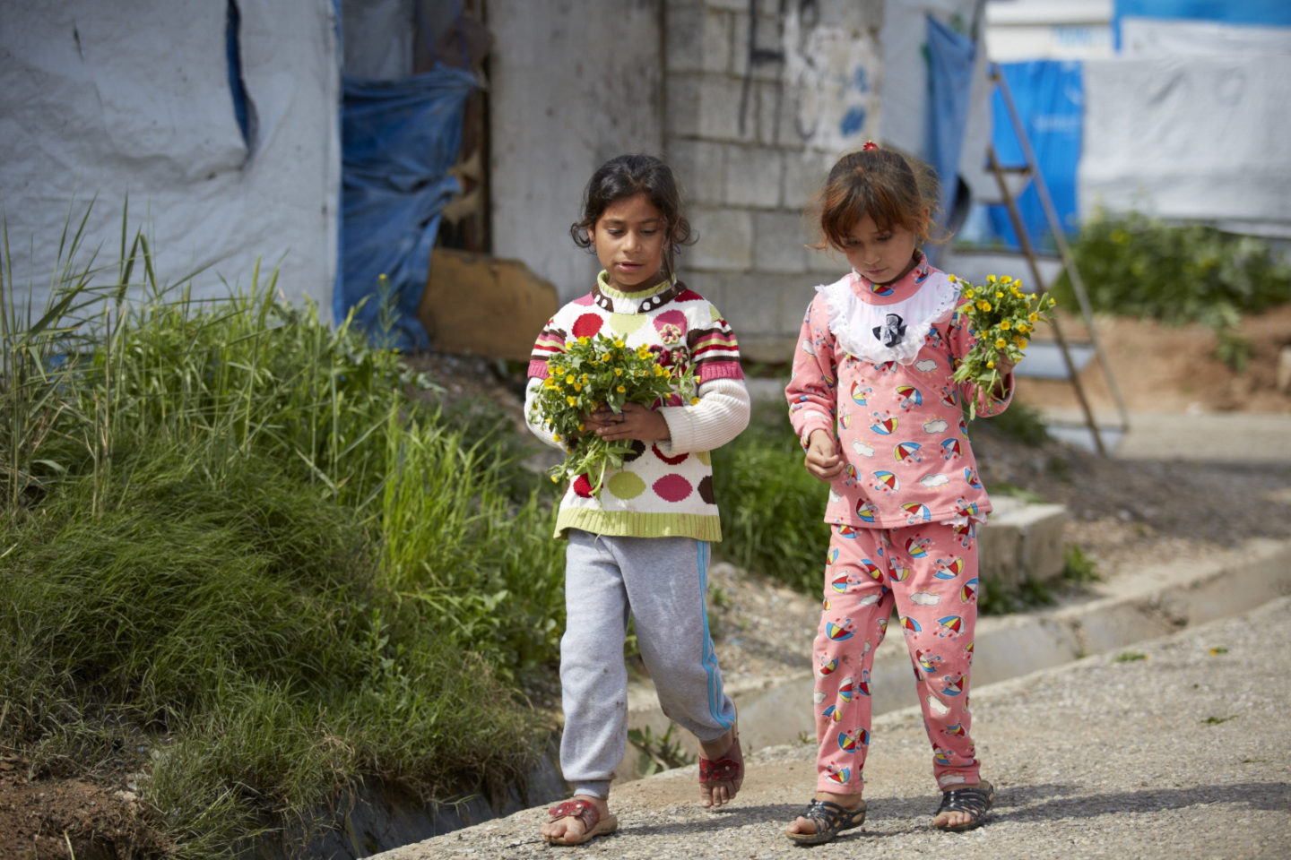 Two girls carrying flowers
