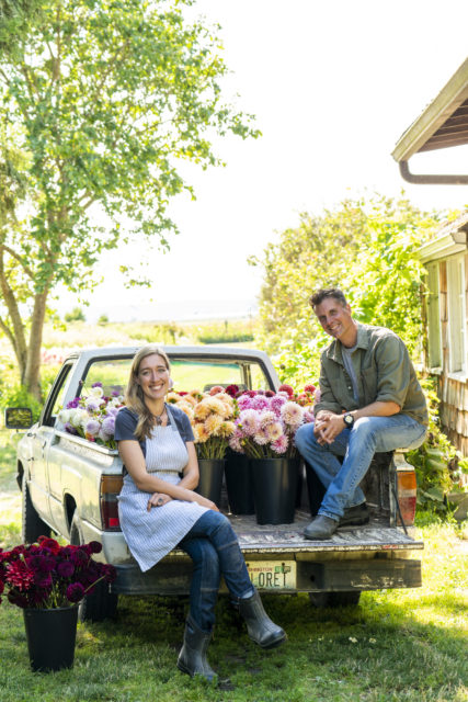 Erin and Chris Benzakein sit in the back of the Floret truck with buckets of dahlias