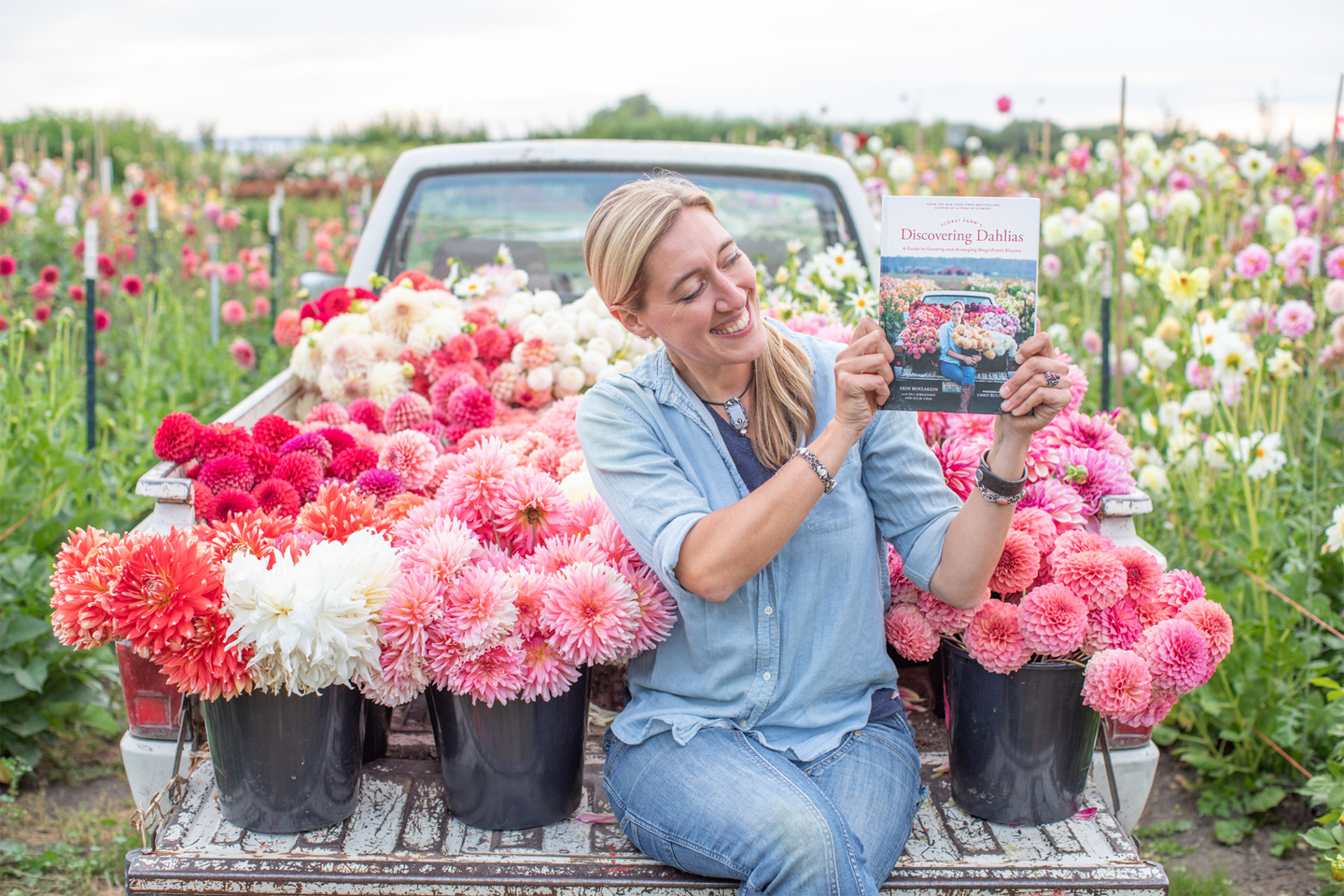 Erin Benzakein in the Floret truck holding a copy of Discovering Dahlias