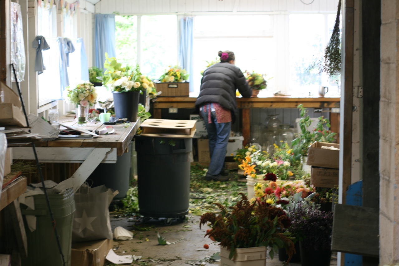 Erin Benzakein making arrangements in a messy studio