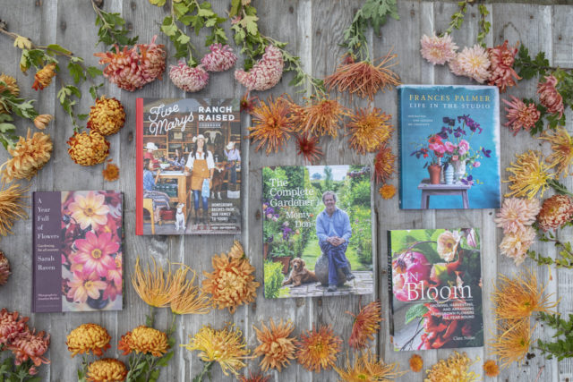 Overhead of Floret's favorite books surrounded by mums