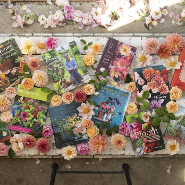 Overhead of Floret's favorite books surrounded by dahlias and roses