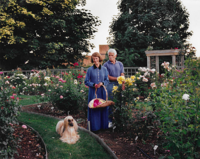Anne Belovich and her husband max in the rose garden with their dog
