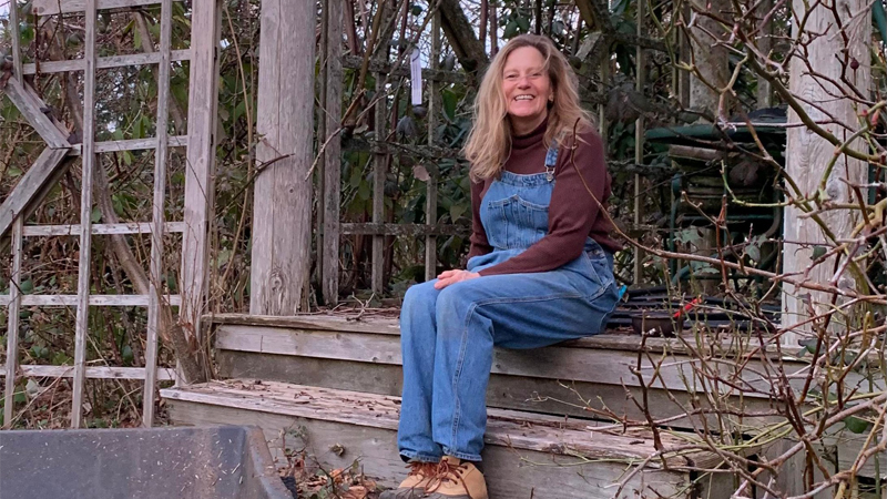 Anne Belovich's daughter-in-law, Teddie Mower, sitting on steps in Anne's garden