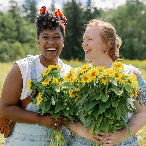 Clary Ager and her wife with handfuls of sunflowers