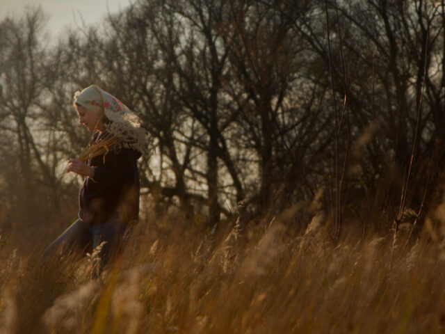 Alla Olkhovska walking through a field in Kharkiv, Ukraine