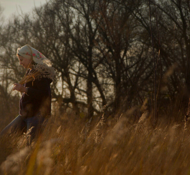 Alla Olkhovska walking through a field in Kharkiv, Ukraine