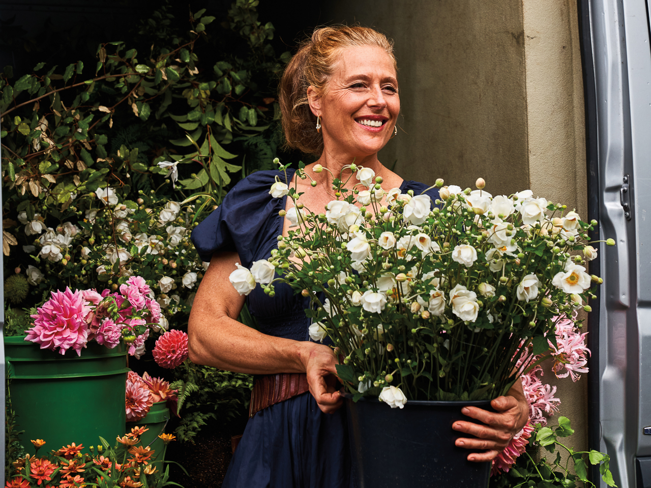 Ariella Chezar holding a bucket of white blooms