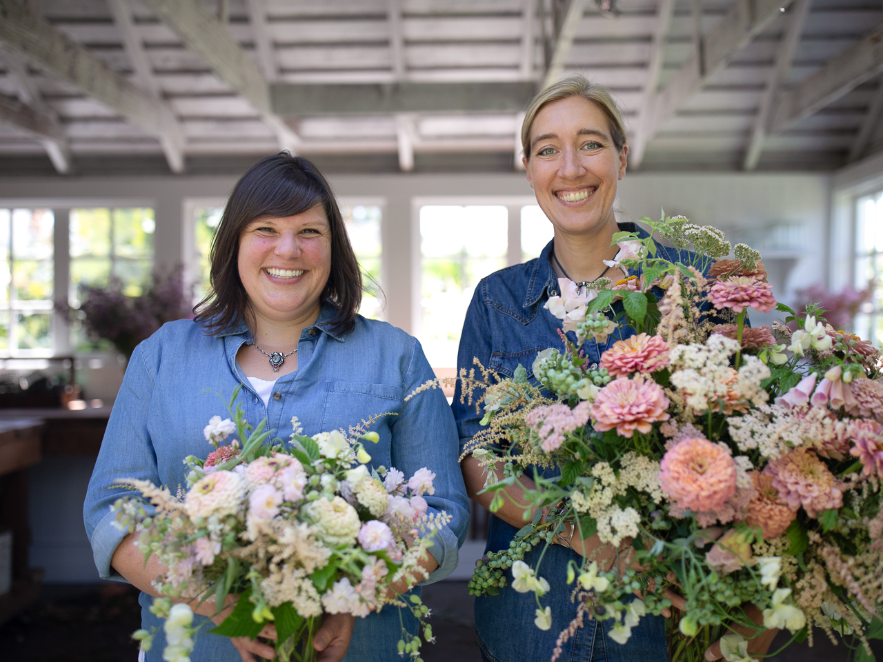 Erin Benzakein and Jill Jorgensen holding seasonal floral arrangements they created